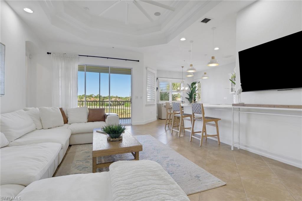 7877 Clemson Street, Unit 202 Naples, FL 34104 - Photo 3 of 36 a living room with furniture and a flat screen tv