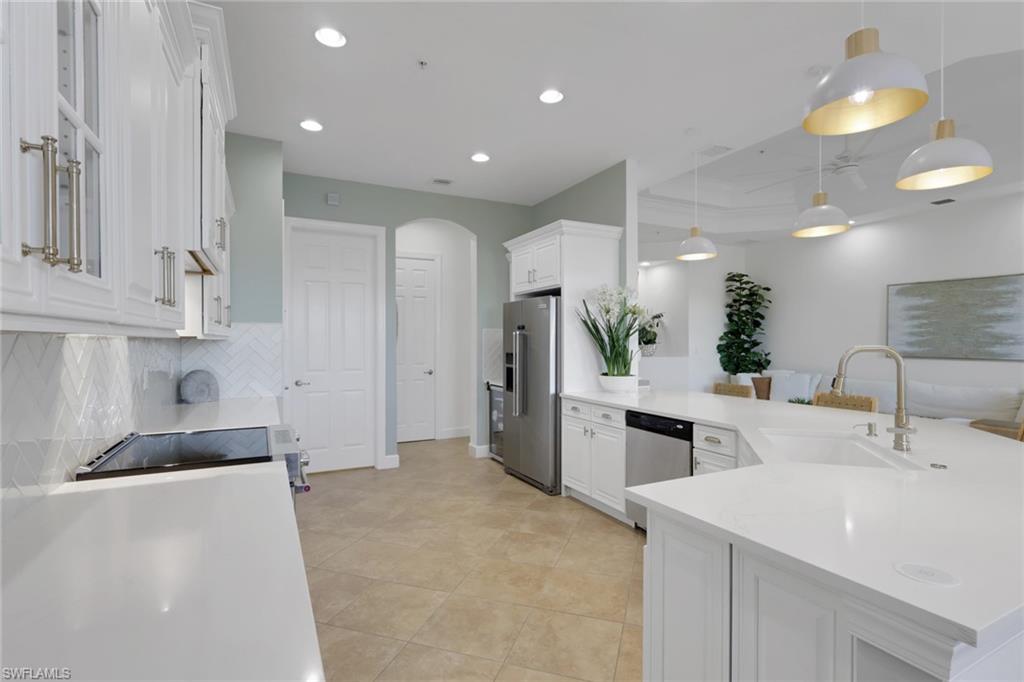 7877 Clemson Street, Unit 202 Naples, FL 34104 - Photo 8 of 36 a kitchen with kitchen island a sink stainless steel appliances and cabinets