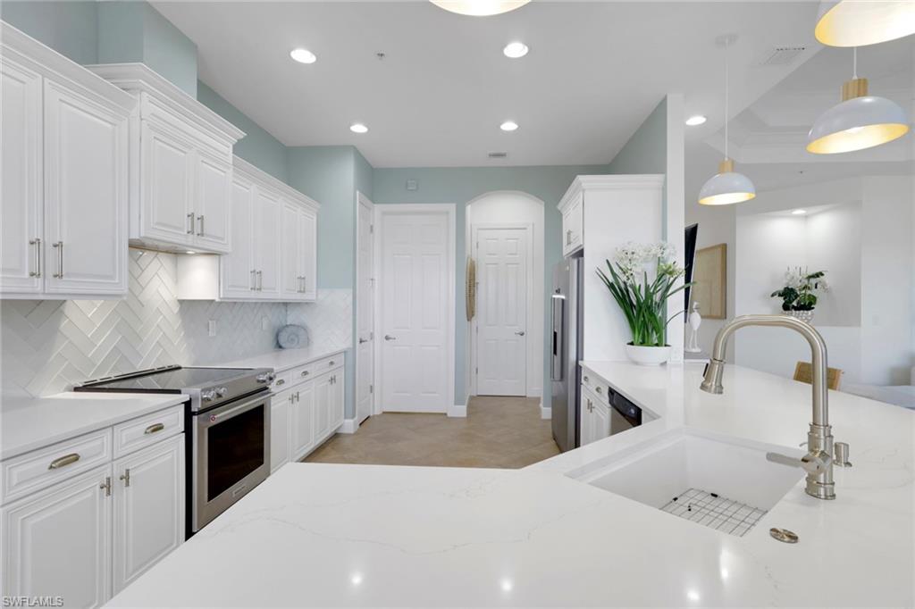 7877 Clemson Street, Unit 202 Naples, FL 34104 - Photo 9 of 36 a kitchen with granite countertop a sink stainless steel appliances and white cabinets