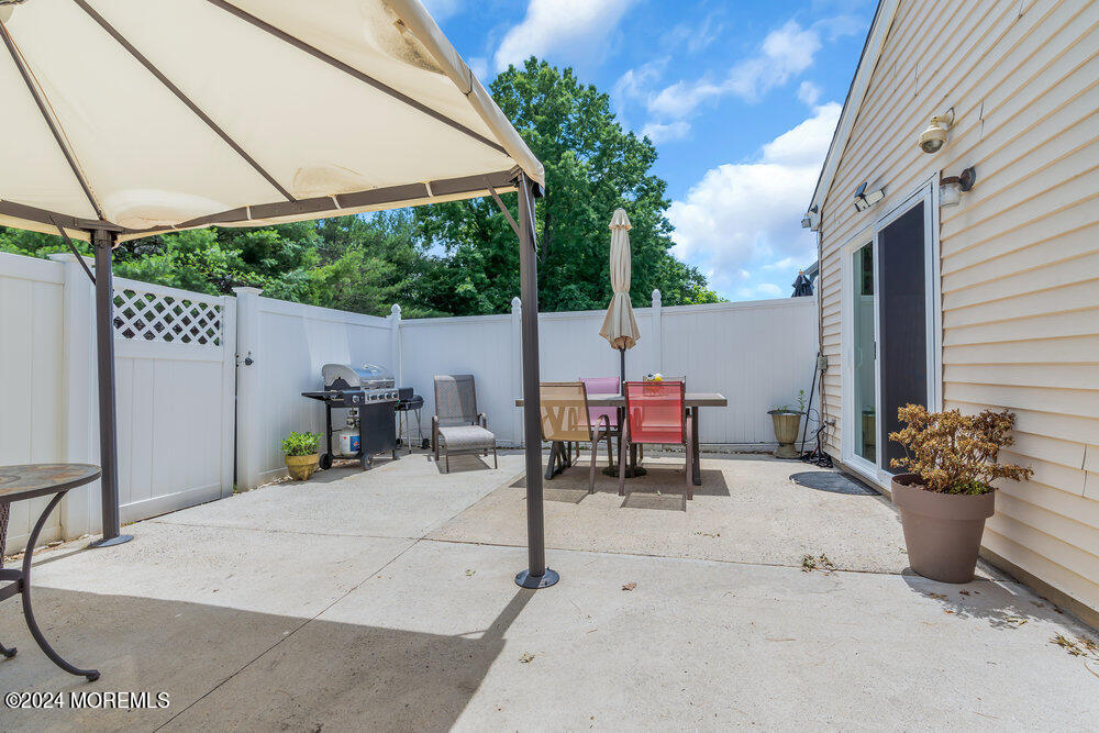 2 Bramble Lane Matawan, NJ 07747 - Photo 25 of 28 a view of a patio with a table and chairs under an umbrella