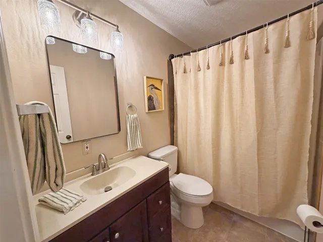 a bathroom with a granite countertop sink toilet and a mirror