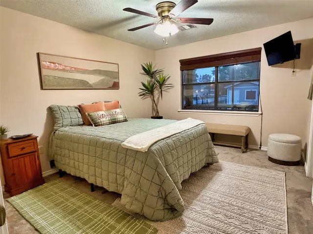 a bedroom with a large bed and a chandelier