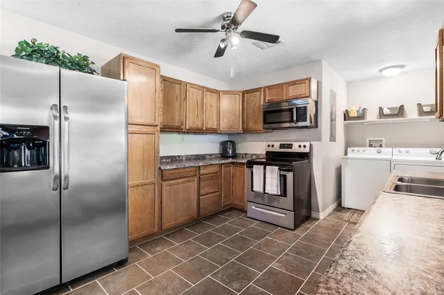 a kitchen with granite countertop a refrigerator stove and microwave