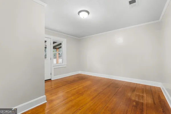 a view of empty room with wooden floor