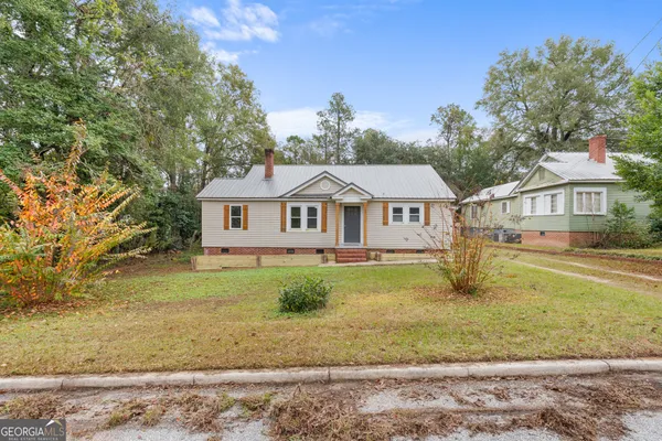 a view of a house with a yard and sitting area