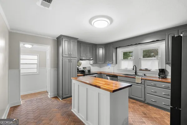 a kitchen with stainless steel appliances granite countertop a refrigerator a sink and a stove