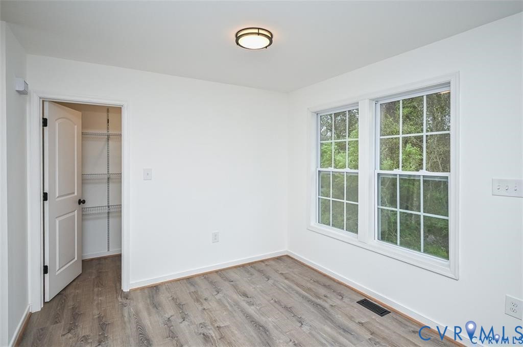 815 Kirby Street West Point, VA 23181 - Photo 12 of 29 an empty room with wooden floor and windows