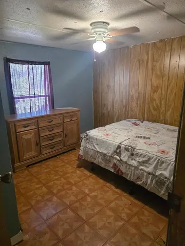 a bedroom with a bed dresser and a window