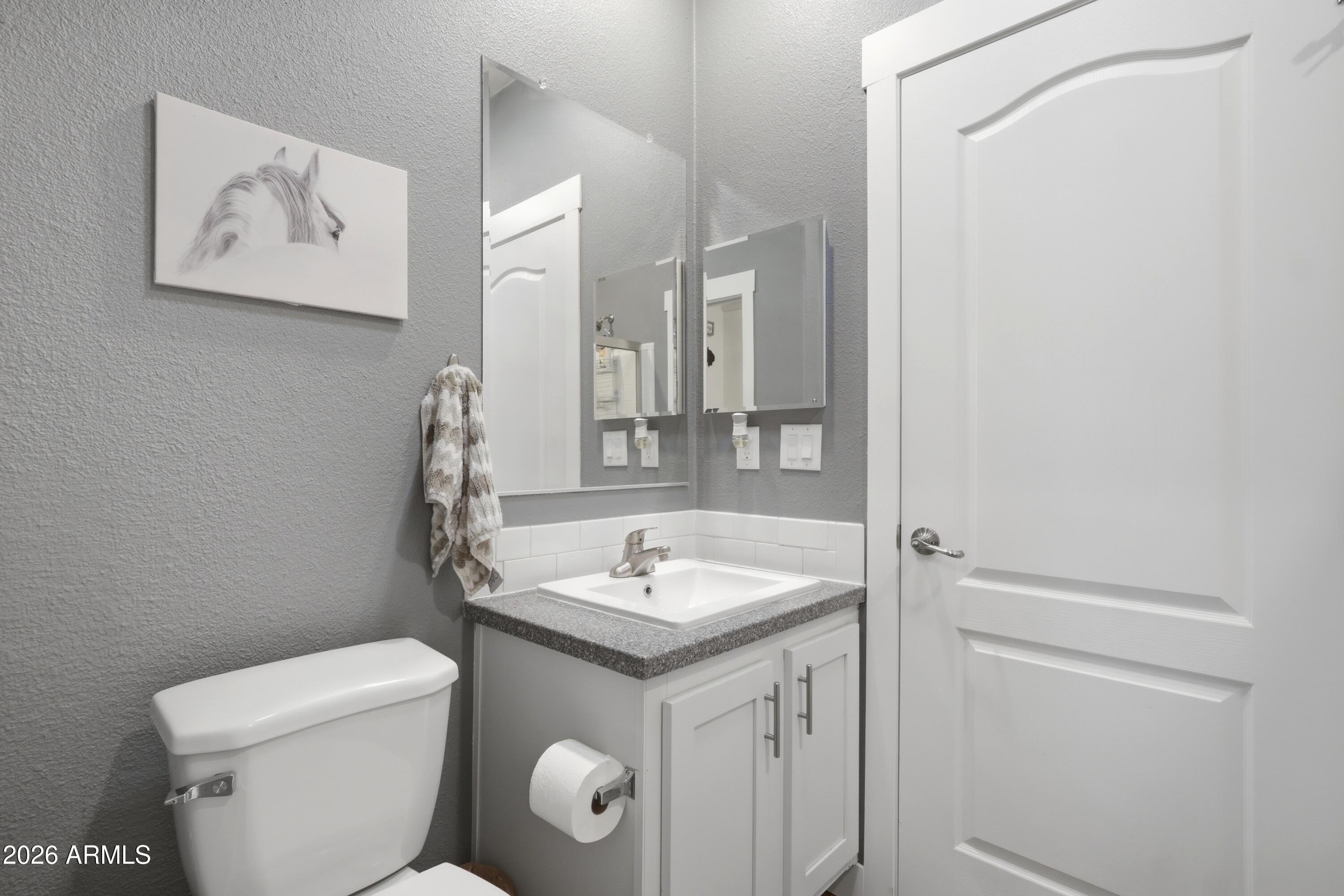 22454 West Steel Horse Road Congress, AZ 85332 - Photo 27 of 44 a bathroom with a granite countertop sink toilet and a mirror