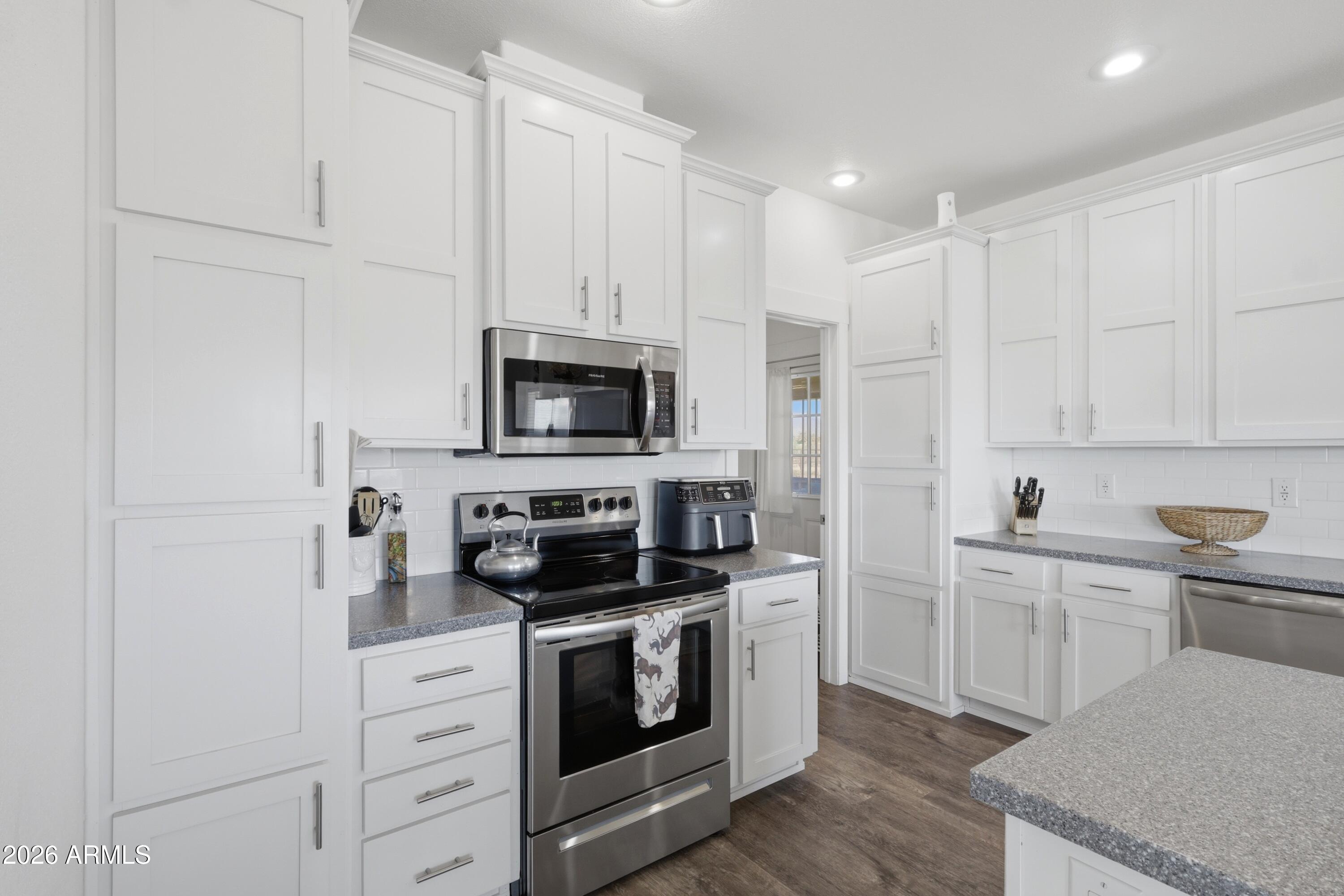 22454 West Steel Horse Road Congress, AZ 85332 - Photo 4 of 44 a kitchen with white cabinets and stainless steel appliances