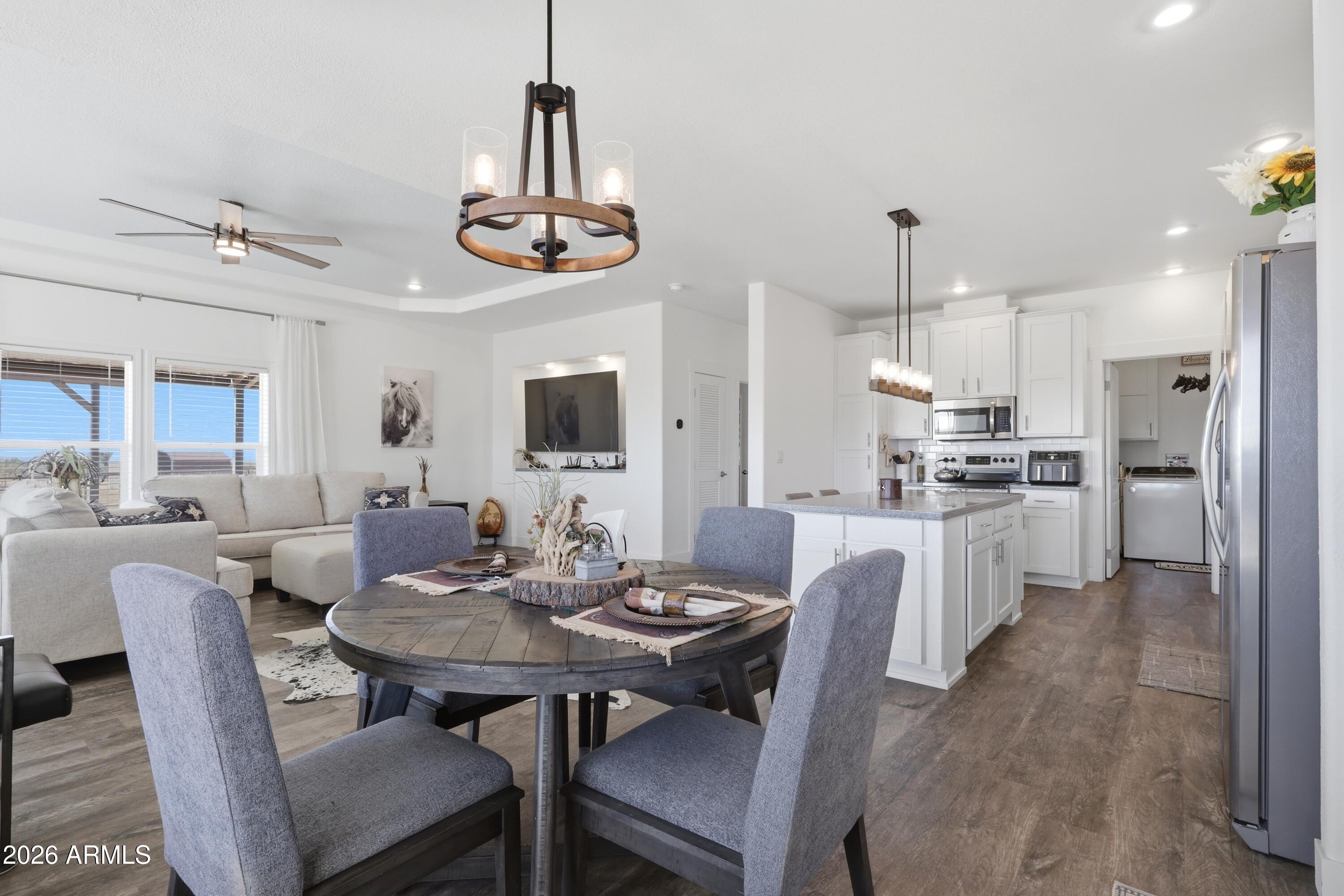 22454 West Steel Horse Road Congress, AZ 85332 - Photo 8 of 44 a view of a dining room and livingroom with furniture wooden floor a chandelier