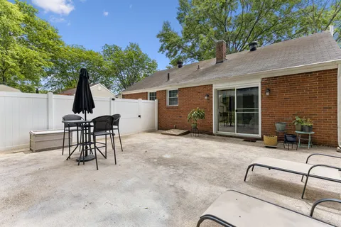 a backyard of a house with table and chairs