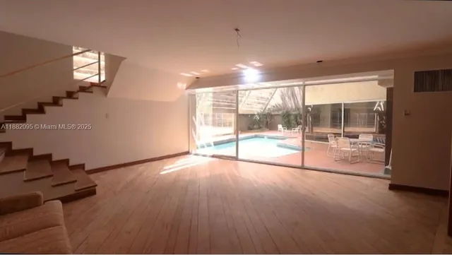a view of a room with wooden floor