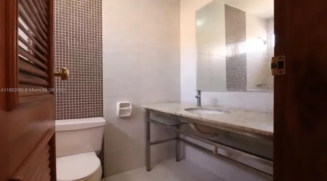 a backyard of a house with a bench and potted plants