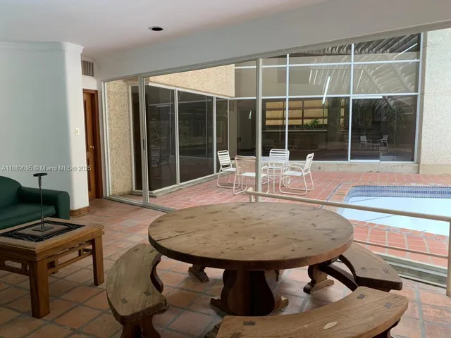a view of a patio with a table and chairs and potted plants