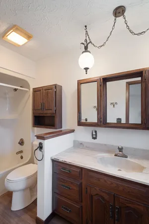 a bathroom with a toilet a sink and mirror