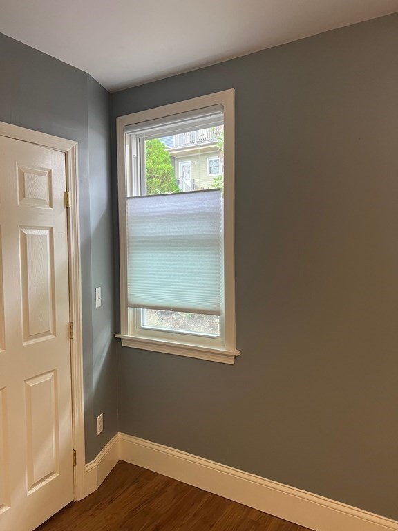 26 Eden Street, Unit 1 Boston, MA 02129 - Photo 15 of 23 an empty room with wooden floor and windows