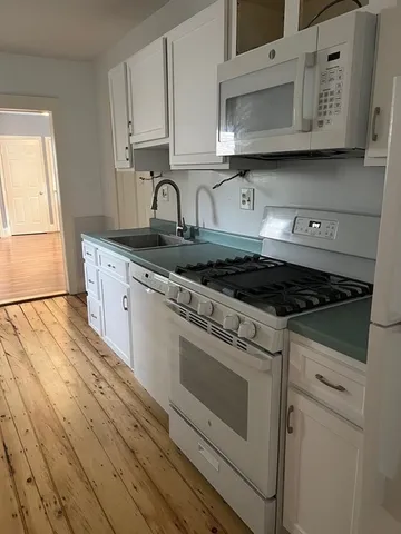 a kitchen with granite countertop a stove sink and cabinets
