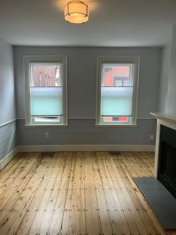 a view of a room with wooden floor and a window