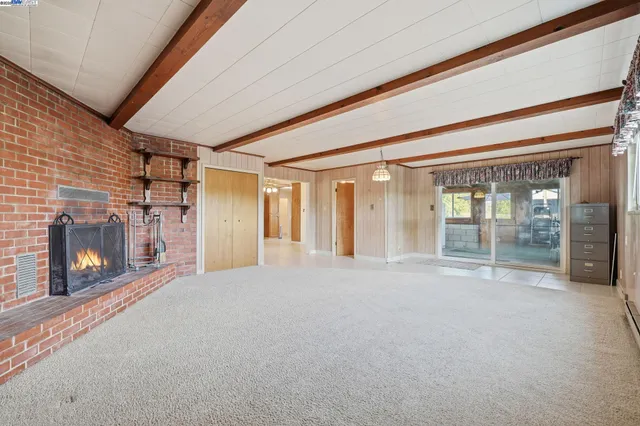 an empty room with a chandelier fan and closet area