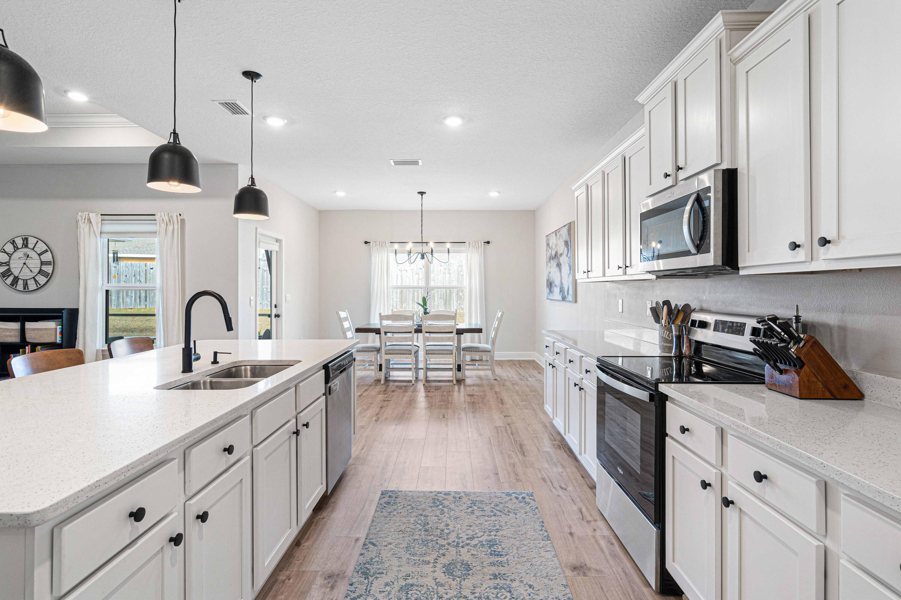58 Siesta Circle Freeport, FL 32439 - Photo 11 of 40 a kitchen with stainless steel appliances granite countertop a sink dishwasher a stove a refrigerator and white cabinets with wooden floor