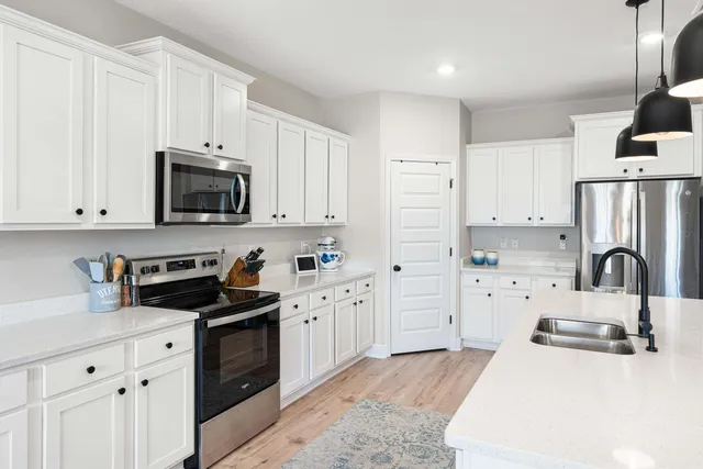 a kitchen with stainless steel appliances a stove sink refrigerator and cabinets