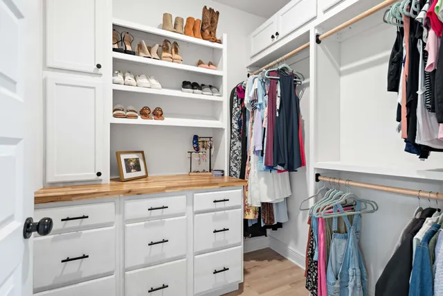 a view of walk in closet with clothes and shoes