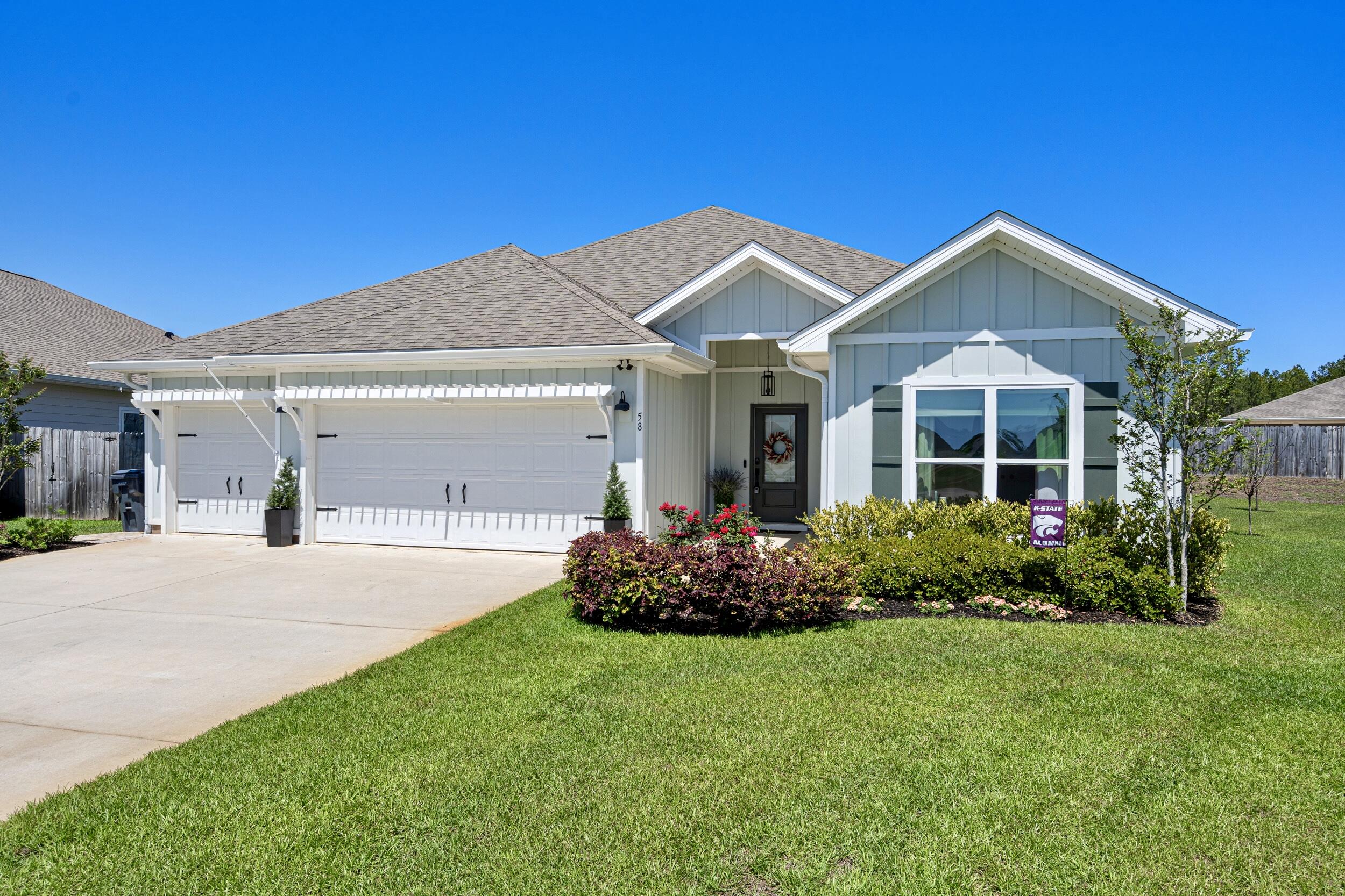 58 Siesta Circle Freeport, FL 32439 - Photo 6 of 45 a front view of a house with a garden and plants
