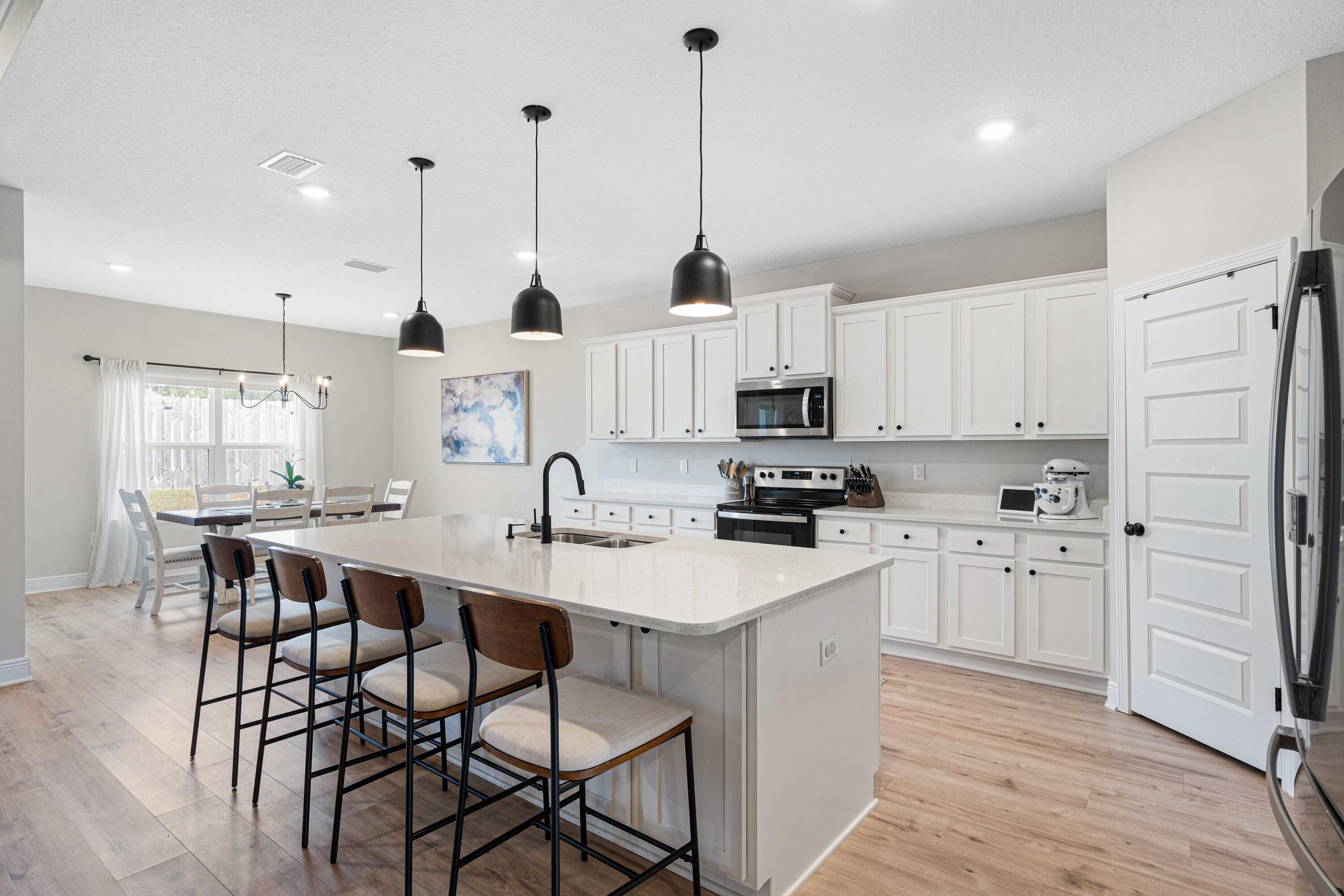 58 Siesta Circle Freeport, FL 32439 - Photo 10 of 40 a kitchen with stainless steel appliances kitchen island granite countertop a sink a stove a dining table and chairs