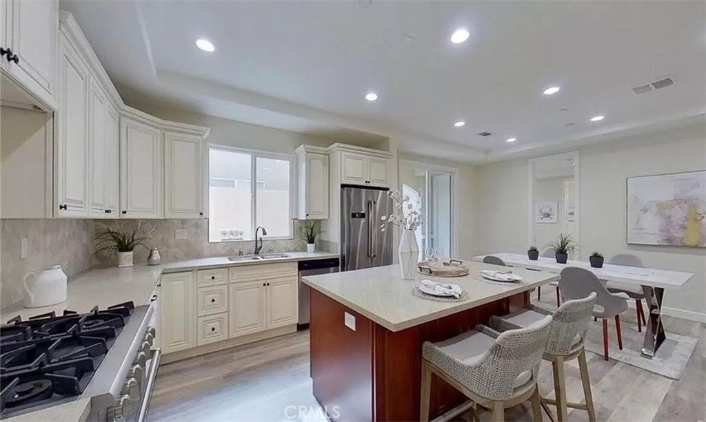 a kitchen with a dining table chairs stove and white cabinets