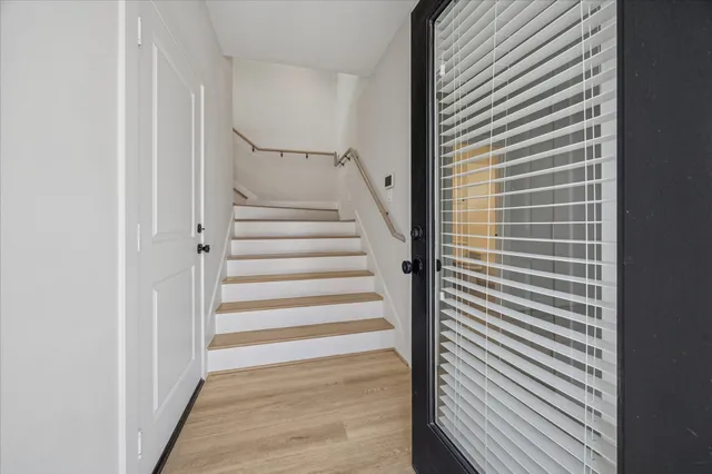 a kitchen with stainless steel appliances granite countertop a stove a sink a refrigerator and a wooden floor