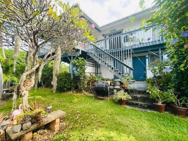a view of an house with backyard and sitting area