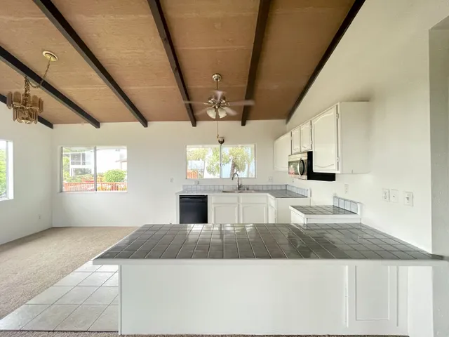 a large white kitchen with a stove top oven a sink and dishwasher
