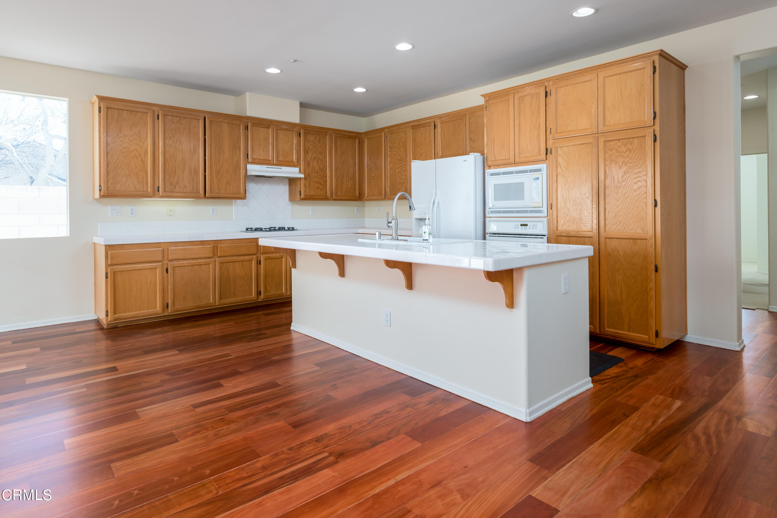 810 Rosalinda Drive Oxnard, CA 93030 - Photo 9 of 24 a kitchen with stainless steel appliances granite countertop a sink a stove a refrigerator and cabinets with wooden floor