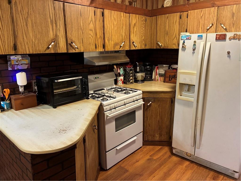244 Manors Mill Road Dallas, GA 30157 - Photo 9 of 39 a kitchen with stainless steel appliances a stove a refrigerator a sink dishwasher and a stove with wooden floor