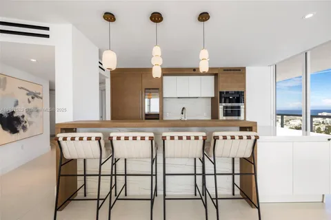 a kitchen with stainless steel appliances granite countertop a stove a sink and white cabinets with wooden floor