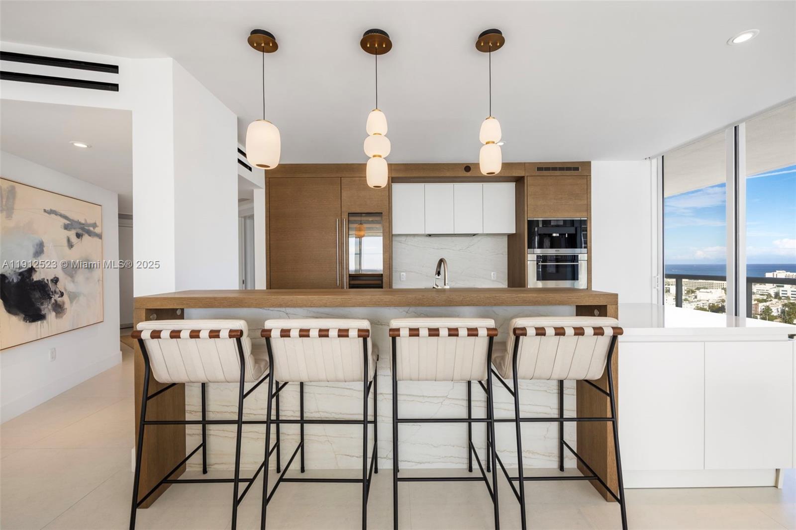 450 Alton Road, Unit 2007 Miami Beach, FL 33139 - Photo 14 of 30 a kitchen with stainless steel appliances granite countertop a stove a sink and white cabinets with wooden floor