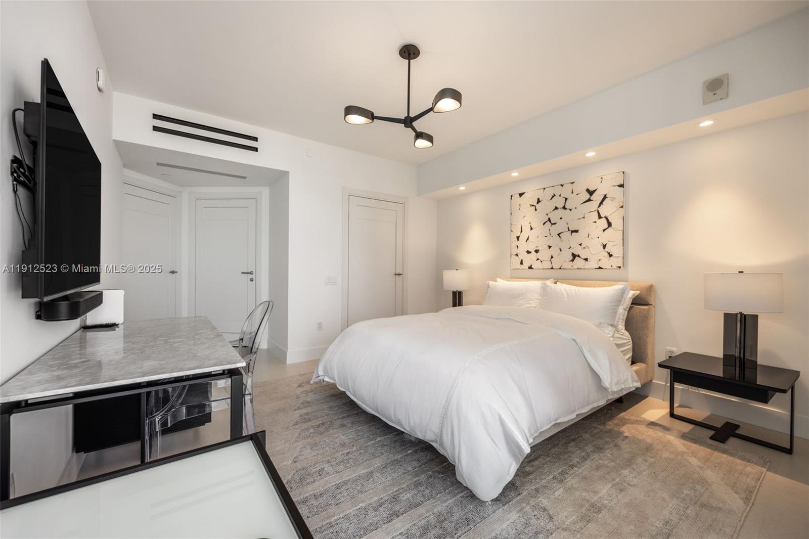 450 Alton Road, Unit 2007 Miami Beach, FL 33139 - Photo 15 of 30 a bedroom with a bed and a flat screen tv