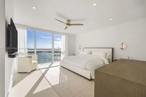 a bedroom with a large bed and a flat tv screen