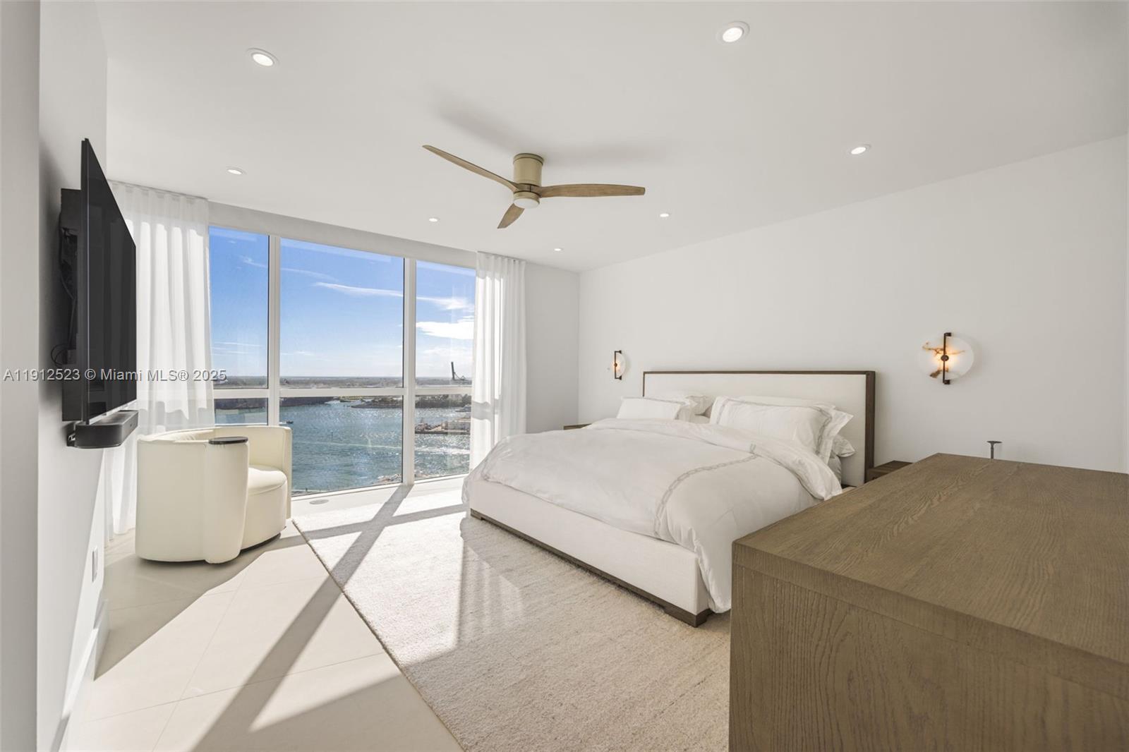 450 Alton Road, Unit 2007 Miami Beach, FL 33139 - Photo 16 of 30 a bedroom with a large bed and a flat tv screen
