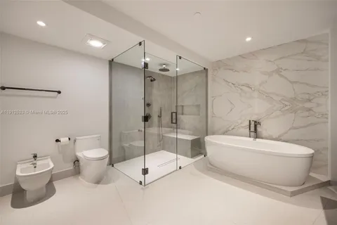 a bathroom with a white toilet sitting next to a bathroom sink and shower