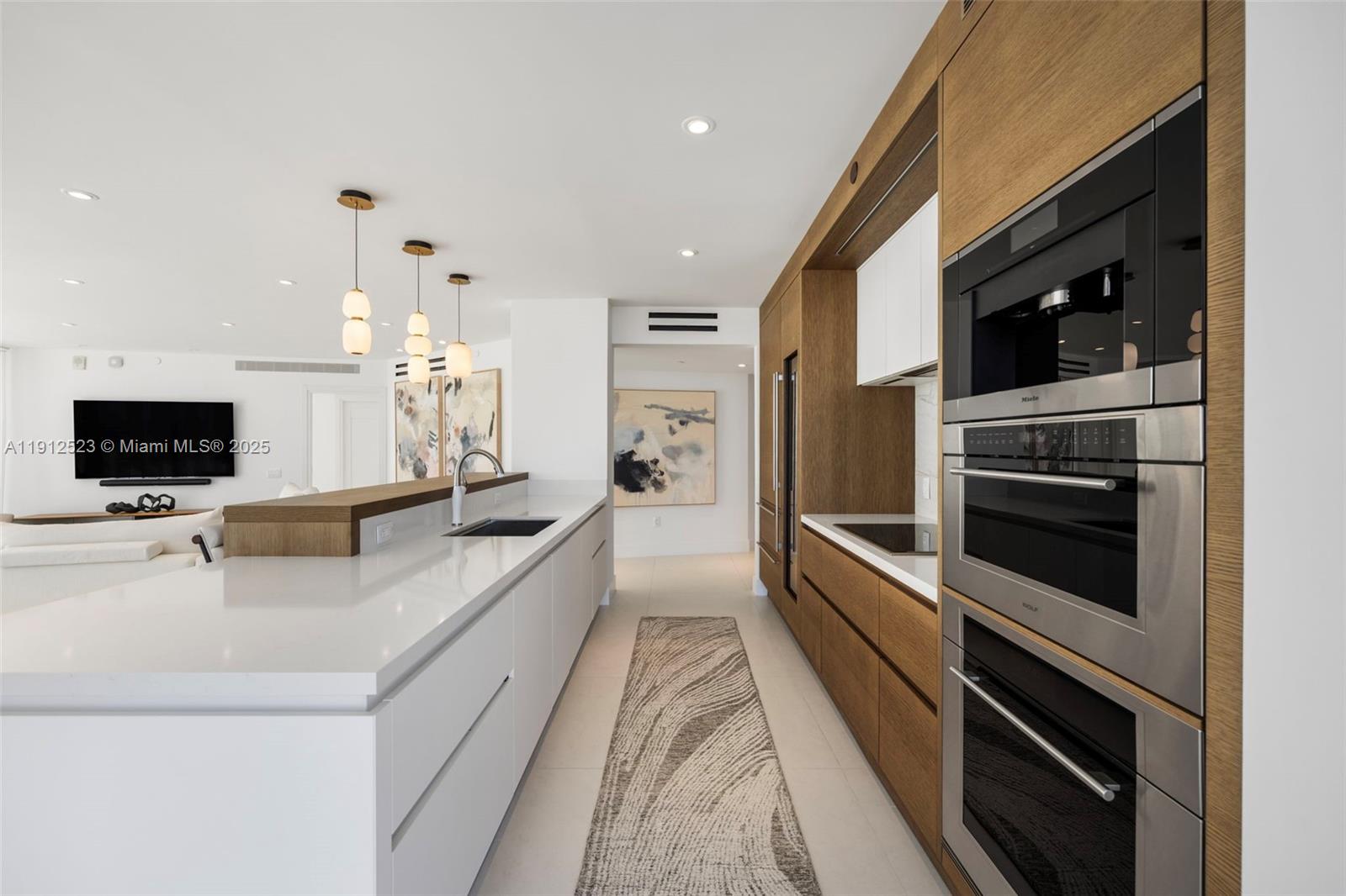 450 Alton Road, Unit 2007 Miami Beach, FL 33139 - Photo 2 of 30 a large white kitchen with a large counter top appliances and a window