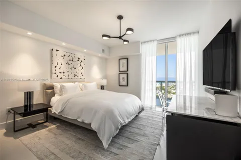 a bedroom with a large bed and a flat screen tv