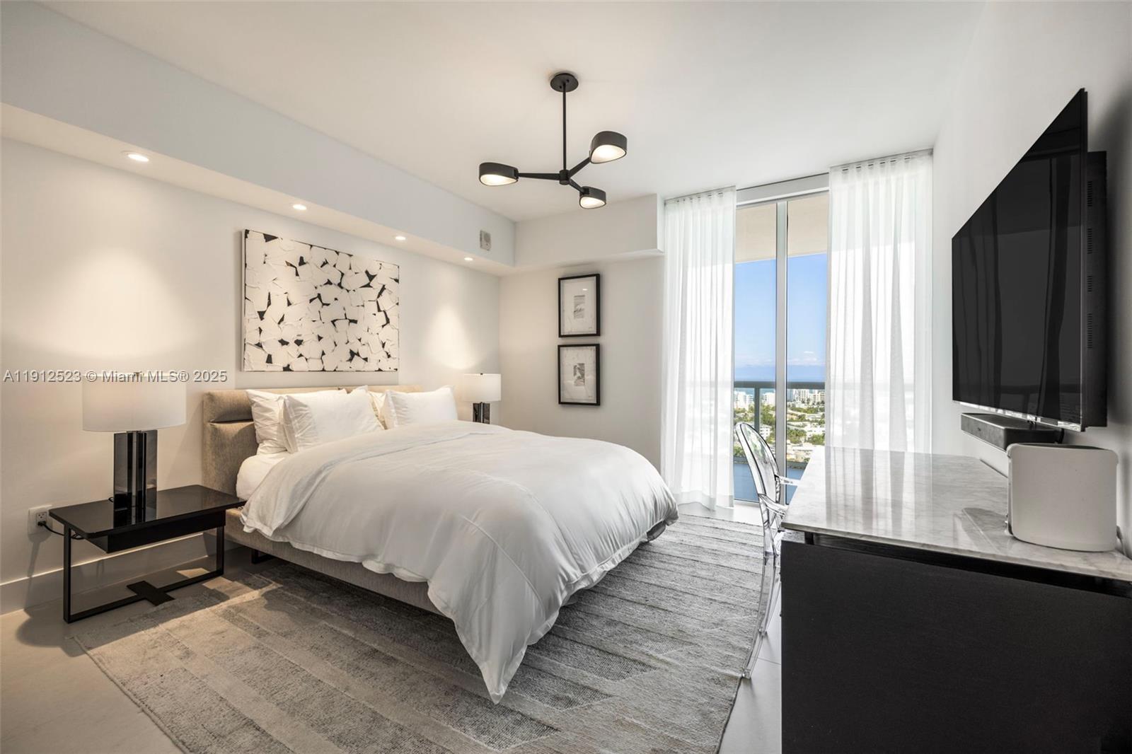 450 Alton Road, Unit 2007 Miami Beach, FL 33139 - Photo 4 of 30 a bedroom with a large bed and a flat screen tv