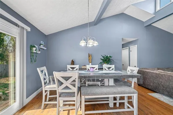 a living room with furniture and a dining table with wooden floor