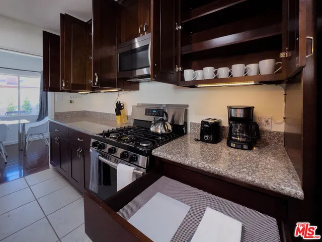 a kitchen with stainless steel appliances granite countertop a stove and a microwave