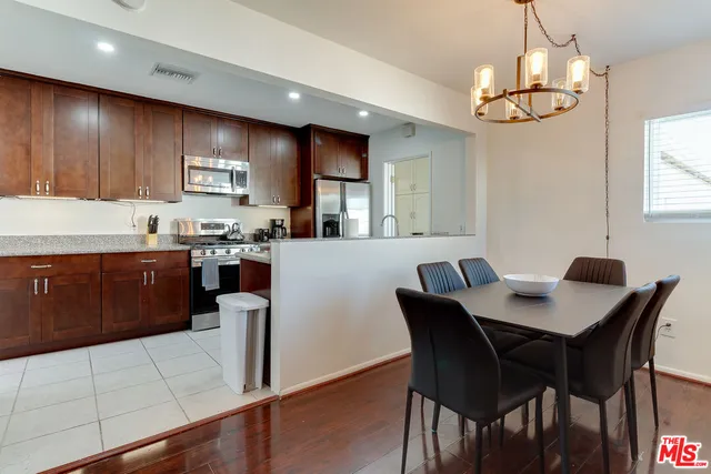 a kitchen with granite countertop a table chairs stove and cabinets