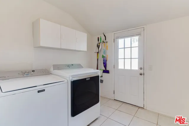 a utility room with cabinets washer and dryer