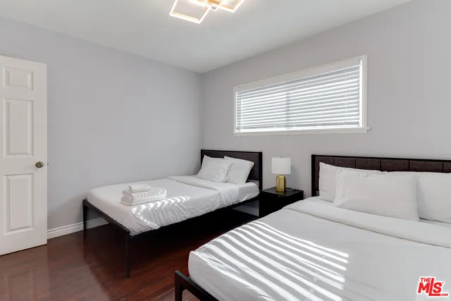 a bedroom with two beds and a window