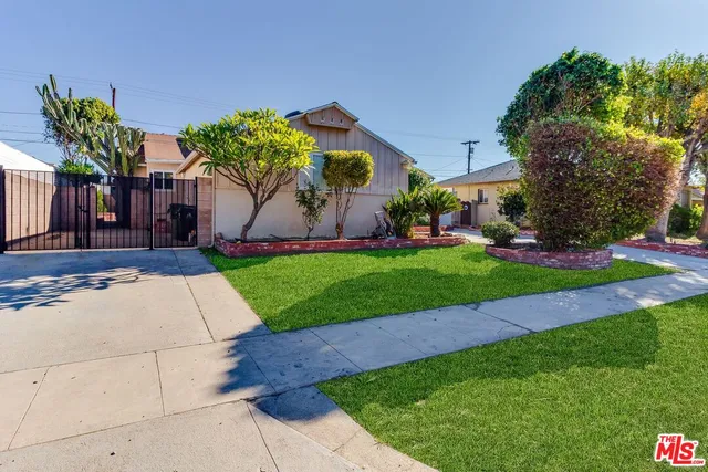 a front view of a house with a yard and potted plants